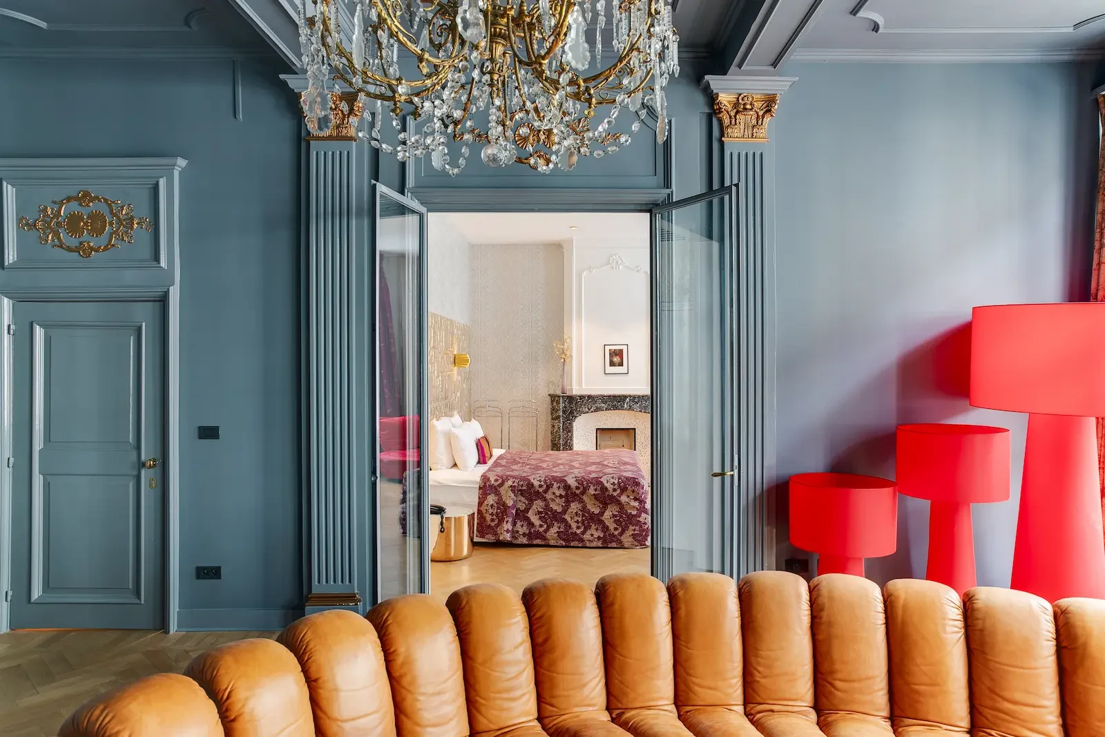 Suite van Hotel De Witte Lelie met kroonluchter, blauw lambrisering en rode designlampen