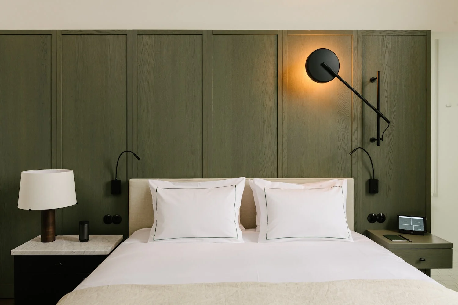 Hotelkamer van August in Antwerpen met groen houten lambrisering en designverlichting